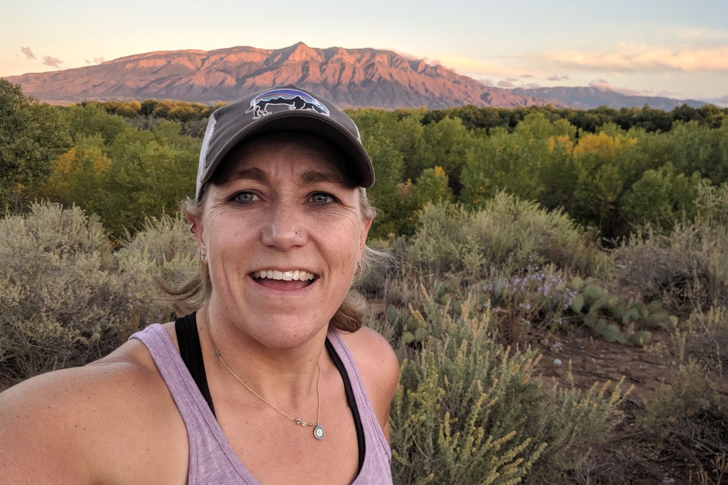 Heidi Miller at sunset with the Sandia Mountains behind her